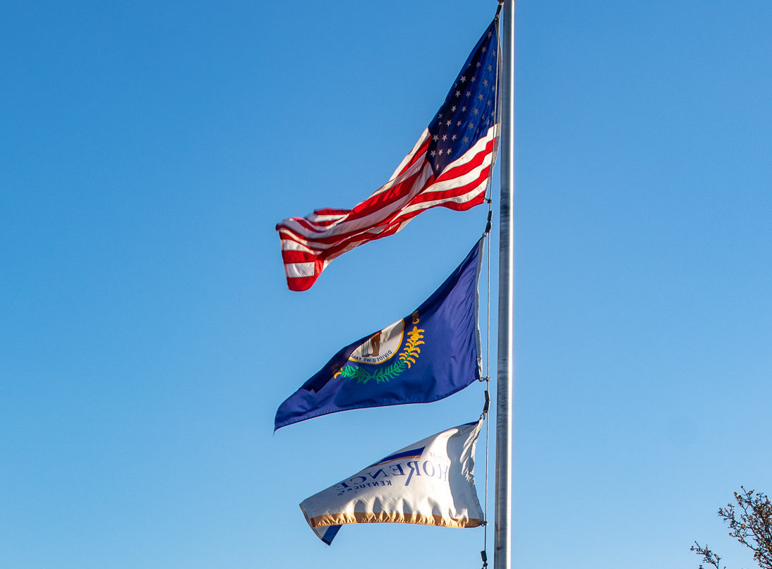 flag pole with the american flag, Kentucky flag, and city of Florence flag